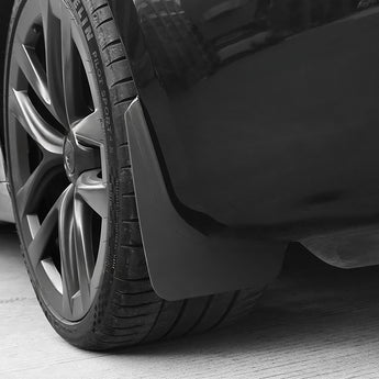 Black mud flap curved to the wheel arch, close-up on tire and rim