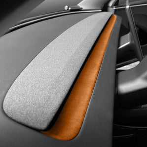 Alcantara dash trim cover with orange accent strip over textured grey surface