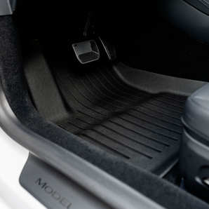 Rear dark rubber floor mat with ridged grooves and 'MODEL' label