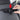 Car backseat hook rail with three hooks, shown with hand adjusting the insert