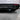Carbon fiber rear diffuser with black fins and central support, red trim highlight