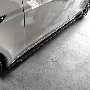 Dark carbon fiber side skirt along rocker panel with textured aero edge.