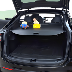 Retracted trunk privacy cover laid across open rear cargo area, dark gray