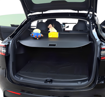Retracted trunk privacy cover laid across open rear cargo area, dark gray