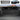 Truck bed cargo divider with perforated MOLLE panel and slotted storage rail