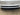 Close-up of front bumper grille insert, dark horizontal slats with diamond mesh center