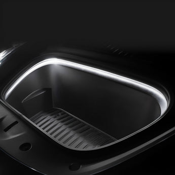 Warm white LED strip close-up along front trunk edge above ribbed tray