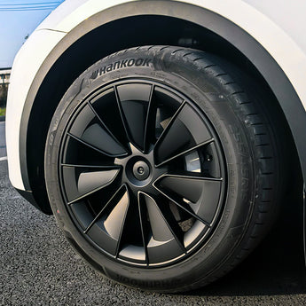 Black wheel cover with multi-spoke turbine design and circular center cap on a tire