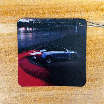 Air freshener card with white sports car top view graphic on night road