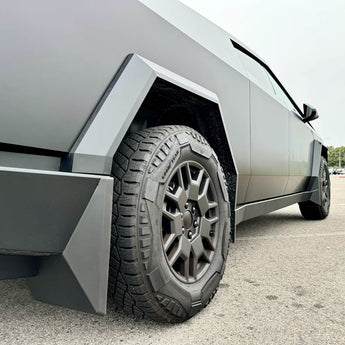 Gray mud flap mounted beside wheel on silver Cybertruck