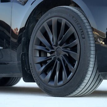 Multi-spoke black wheel cover with center cap; tire tread visible