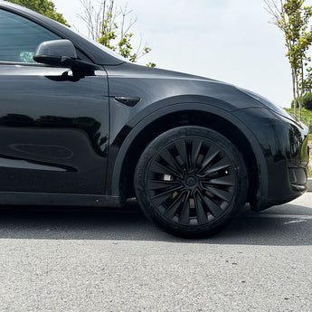 Black multi-spoke wheel cover on the front wheel of a car