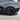 Black multi-spoke wheel cover on a rear wheel, viewed from an angled side