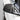 Black carbon fiber mirror cap on a car side mirror, glossy weave texture and curved housing.