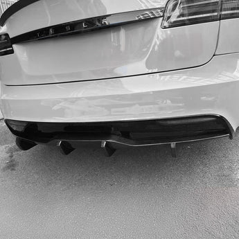 Carbon fiber rear diffuser with black grille inserts and vent fins along the edge