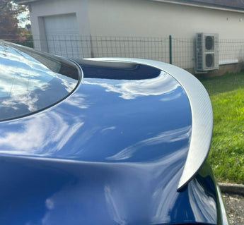 Carbon fiber rear spoiler installed, highlighting curved outline and woven finish