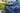 Carbon fiber rear spoiler on blue Tesla Model S trunk lid, close rear-corner view