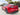 Carbon fiber rear diffuser installed on a red car with dark diffuser fins