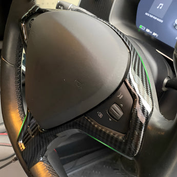 Carbon fiber steering wheel trim panel with black woven texture and chrome edge