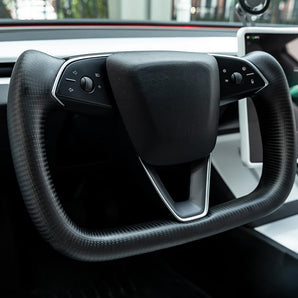 Installed heated steering wheel yoke with black carbon fiber grips and control panel