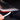 Hand applying headlight trim film strip with red edge to a car tail light