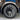 Dark gray induction-style wheel cover with multi-spoke design and visible tire