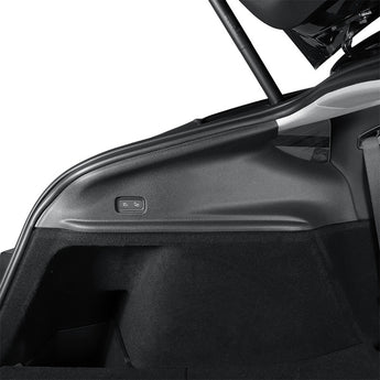 Tesla Model Y side trunk upper protector installed on dark interior trim near a button
