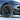 Dark multi-spoke wheel cover with center cap on tire, angled view