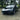 Glossy black front lip spoiler add-on on a black Tesla with sporty lower bumper styling