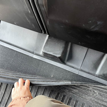 Black TPE underseat protector cover aligning near a molded anchor opening