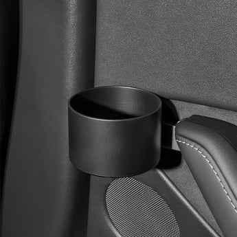 Black door cup holder mounted on car door panel beside textured speaker grille