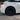 Rear wheel close-up with black multi-spoke wheel cover on a white car