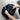 Wheel cover storage bag, black, partially covering an alloy wheel as hands adjust it
