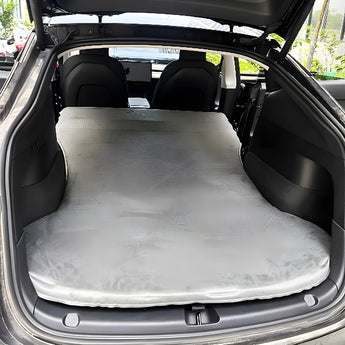 Fully inflated gray suede-style air mattress in a car trunk