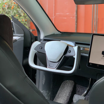 Installed steering wheel airbag cover with white center panel and black trim