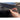 Carbon fiber door handle cover, dark woven finish, held in place on car