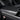 Carbon fiber armrest cover with glossy dark weave finish on center console