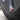 Red aluminum valve stem cap on tire valve stem, close view on wheel rim