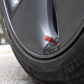 Red aluminum valve stem cap on tire valve stem, close view on wheel rim
