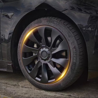 Dark gray aero wheel cover with spoke design, installed on front tire