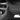 Black mud flap with thin blue trim line, mounted along car rocker panel
