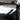 Black Alcantara door panel trim insert with orange ambient accent strip and circular speaker opening.