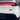 Chrome and red rectangular emblem with radial stripe design on white car