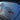 Rectangular chrome emblem with red radial lines on blue car trunk
