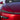 Smoked UV-reactive headlight bar film over front light strip on red car