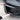 Hand installing black fog light trim cover on the front bumper opening