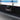 Black anti-theft license plate holder with bracket and screw points, close-up