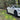 Outdoor side view: dark multi-spoke wheel cover with center cap on the car’s front wheel