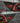Single dark carbon fiber charging port cover panel with cutout and red lens