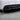 Close-up carbon fiber rear diffuser corner with red reflector strip and black fins